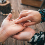 Close up of fortune teller point her finger to woman's palm line and read her fortune. Palmistry cpncept